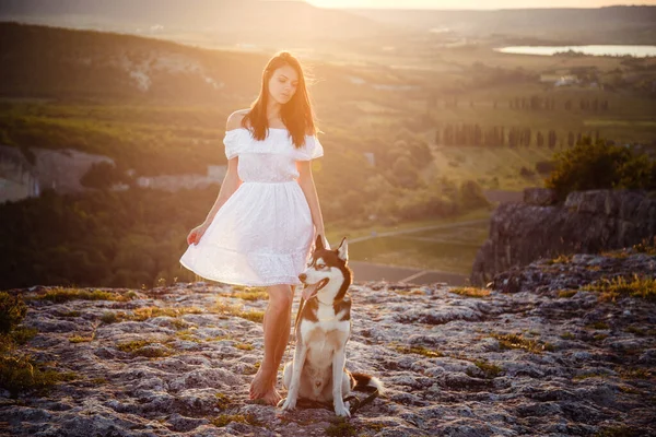 高い山の中に座って晴れた日にハスキー犬と若い女性 自由と幸福の概念 観光と冒険 — ストック写真