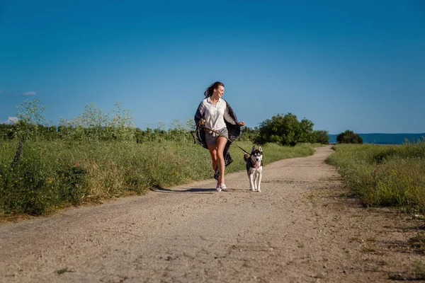 Sportlerin Läuft Mit Hund Dem Sibirischen Husky Auf Der Straße — Stockfoto