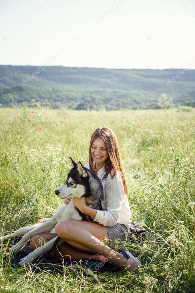 Beautiful young woman playing with funny husky dog outdoors at park. Summertime and sunset. Unconditional love. Siberian husky favorite pet. Animal husbandry. Pedigree dog concept. Best friends.