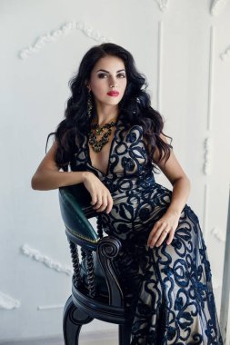 Şık, esmer, seksi, şık elbiseli bir kadın. Kırmızı dudaklı çekici kız modeli, uzun dalgalı saç stili.