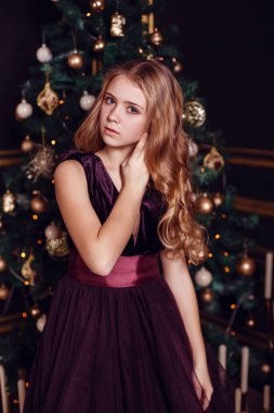 Mumlar ve hediyelerle köknar ağacı ve şömine önünde rahibeler. Yeni yıl arifesi. Noel arifesi. Köknar ağacında sıcak bir tatil Işıklar ve altın dekor ile.