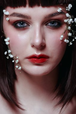 Taze, pürüzsüz bir teni, pembe arka planda çiçekli çıplak makyajı olan genç ve güzel bir kadının stüdyo güzelliği portresini kapat. Moda fotoğrafı.