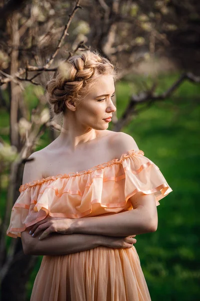 一个金发碧眼的女孩 穿着浅色的衣服 躺在花园子里 女性春季时尚的概念 年轻模特儿看着相机的表现力 — 图库照片
