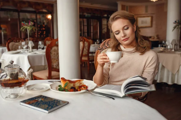 Vacker Ung Kvinna Läser Bok Medan Hon Sitter Restaurang Rasten — Stockfoto