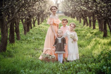 Güzel kızlar ve ablaları çiçeklerle dolu bahçede yürüyüş yapıyorlar. Arkadaş canlısı bir aile ve mutlu bir çocukluk fikri. Retro elbiseler