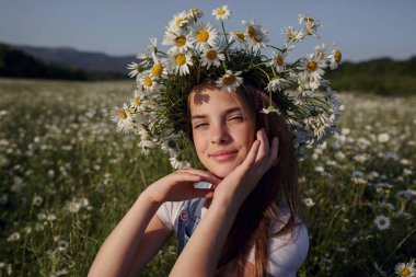Papatya tarlasında baharın tadını çıkarıyor. Mutlu çocukluk kavramı ve fikri. Güneşli bir yaz gününde çayırda kot pantolon giyen genç.