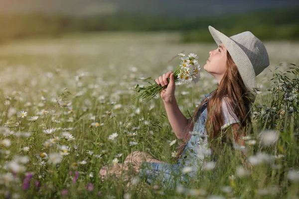 戴着帽子在菊花地里享受春天 幸福童年的概念和理念 夏日阳光明媚的草地上 穿着牛仔工作服的少年 — 图库照片
