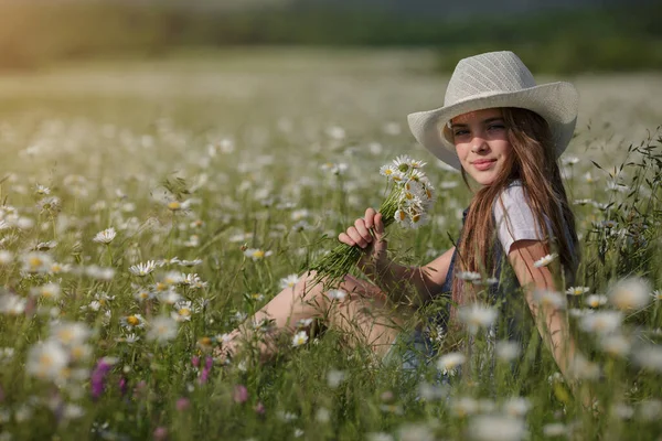 戴着帽子在菊花地里享受春天 幸福童年的概念和理念 夏日阳光明媚的草地上 穿着牛仔工作服的少年 — 图库照片