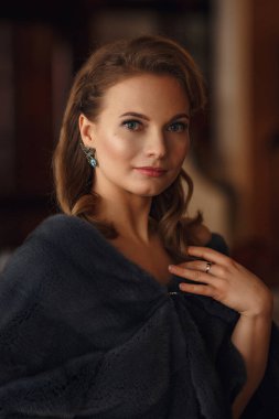 Teras restoranında bir etkinlik bekleyen güzel genç bir kadın. Şenlik ve etkinliklere hazırlanıyorum. Deniz manzaralı lüks bir elbise.