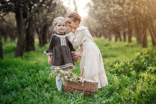 2人の姉妹やガールフレンドが庭を歩いていて 美しいヴィンテージのドレスで春を楽しんでいます 優しい家族と幸せな子供時代のアイデアとコンセプト イースターの時間と目覚め — ストック写真