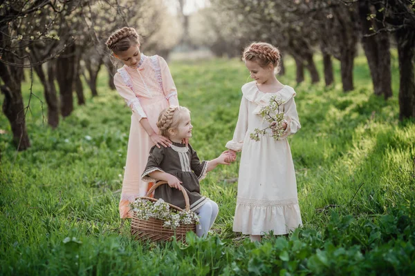 三个穿着复古服装的漂亮姑娘在一个花园子里散步 友好家庭和幸福童年的理念和概念 — 图库照片