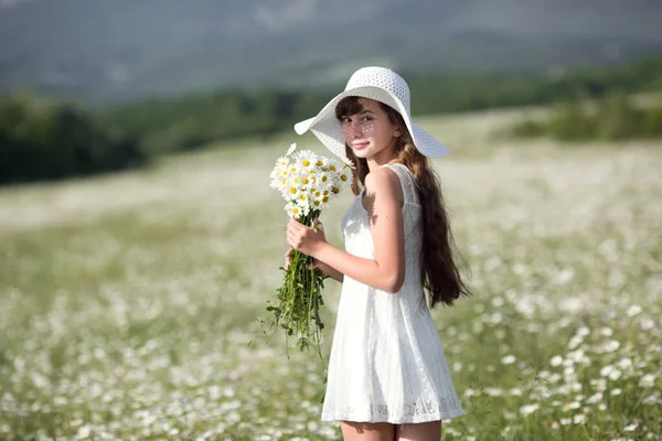 漂亮可爱的少女在雏菊田里散步 身穿白衣 头戴白帽 快乐成长 健康与过敏 皮肤与头发护理的理念与概念 — 图库照片