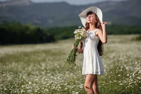 漂亮可爱的少女在雏菊田里散步 身穿白衣 头戴白帽 快乐成长 健康与过敏 皮肤与头发护理的理念与概念 — 图库照片