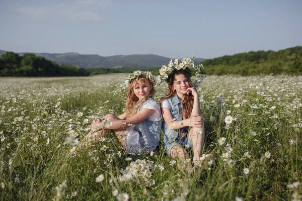 Twee Schattige Tienermeisjes Denim Overall Lopen Een Madeliefje Veld Idee — Stockfoto