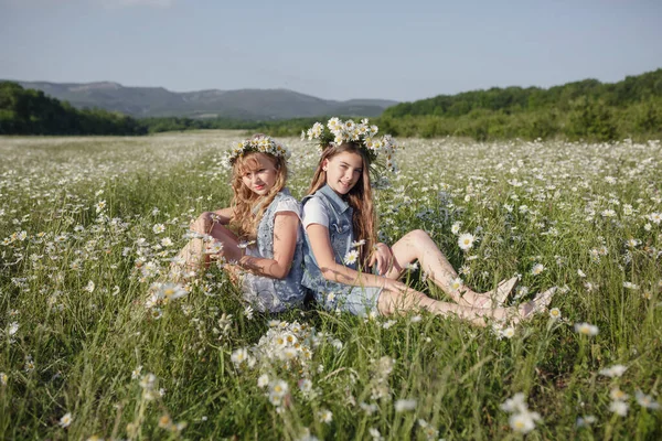 Twee Schattige Tienermeisjes Denim Overall Lopen Een Madeliefje Veld Idee — Stockfoto