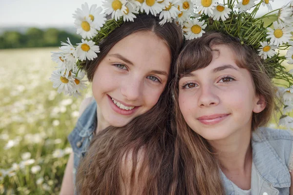 两个可爱的少女 穿着牛仔 美丽健康的棕色长发 在雏菊地里 关于健康 快乐童年 友谊的观念和概念 — 图库照片