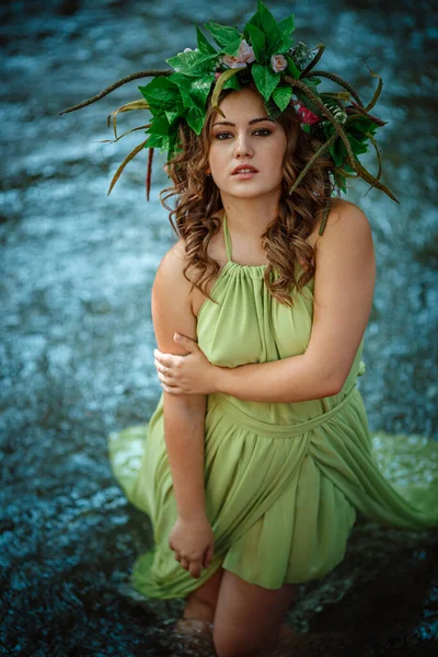 美丽的年轻女子穿着绿色的衣服 戴着花环 在阳光灿烂的森林里 在仲夏或地球日举行的仪式 童话和幸福的概念和概念 — 图库照片