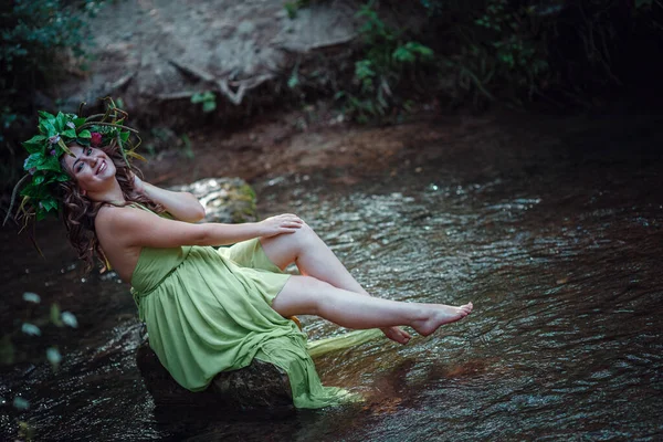 美丽的年轻女子穿着绿色的衣服 戴着花环 在阳光灿烂的森林里 在仲夏或地球日举行的仪式 童话和幸福的概念和概念 — 图库照片