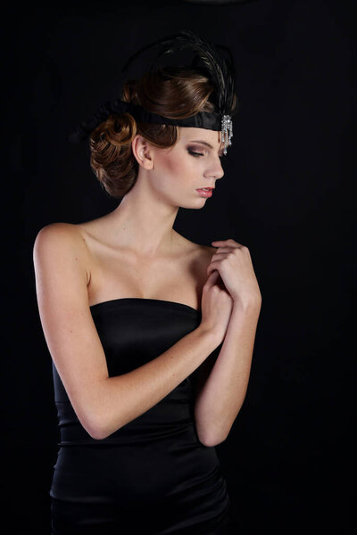 Beautiful woman in the style of Art Nouveau, the era of gangsters. Fashion clothes, make-up and hair in luxurious retro style the roaring 20s.