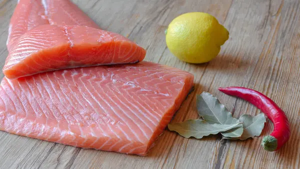 Fresh raw salmon fillet on a wooden background. Selective focus — 스톡 사진