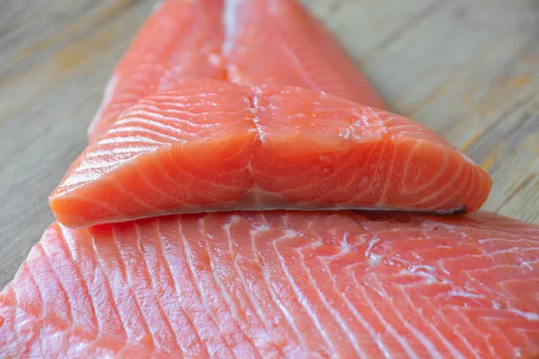 Fresh raw salmon fillet on a wooden background. Selective focus — 스톡 사진