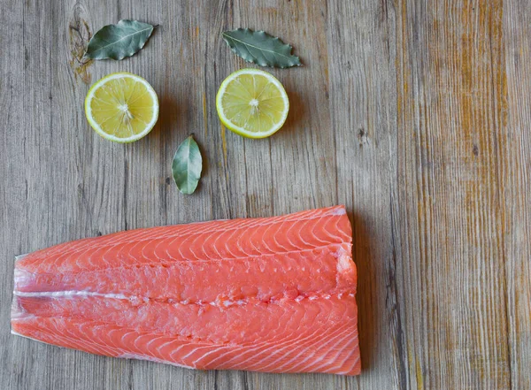 Fresh raw salmon fillet on a wooden background. Top view, selective focus. — 스톡 사진