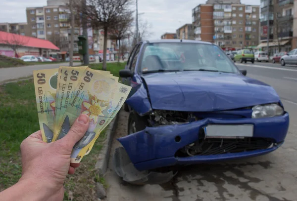 Vehículo dañado después de un accidente de coche estacionado en la carretera. Concepto de seguro de coche con dinero rumano (lei) - el costo del seguro de coche o la falta de seguro de coche es caro. Enfoque selectivo . —  Fotos de Stock