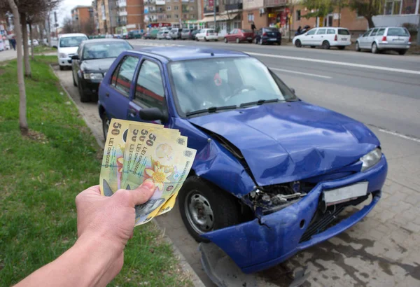 Vehículo dañado después de un accidente de coche estacionado en la carretera. Concepto de seguro de coche con dinero rumano (lei) - el costo del seguro de coche o la falta de seguro de coche es caro. Enfoque selectivo . —  Fotos de Stock