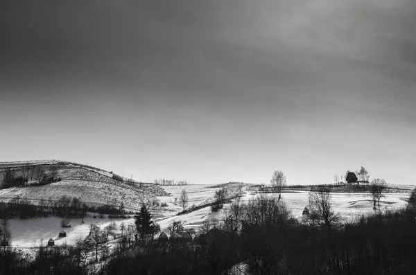 Casas tradicionais na aldeia de Dumesti, Montanhas Apuseni, região da Transilvânia, Roménia, no inverno, fotos em preto e branco — Fotografia de Stock