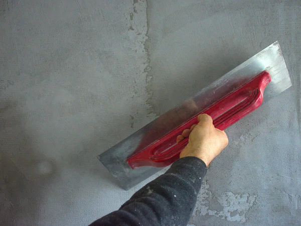 建筑工地的工人用水泥和钢丝绳在混凝土墙体上涂上工人的手印并使之平滑 — 图库照片