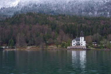 Grundlsee, Avusturya, Styria 'daki en büyük göl, ve onun güzel Villa Castiglioni' si, sisli bir kış sabahı, harika dağ manzarasında battı.