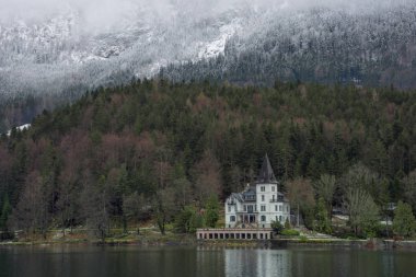 Grundlsee, Avusturya, Styria 'daki en büyük göl, ve onun güzel Villa Castiglioni' si, sisli bir kış sabahı, harika dağ manzarasında battı.