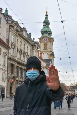 Graz/Austria - March 09, 2020: Man on city street wearing a face mask for protection against viruses during coronavirus COVID-19 and flu outbreak