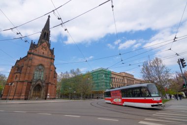 Brno, Çek Cumhuriyeti - 1 Mayıs 2017: Güney Moravya 'nın Brno kentinde Kızıl Kilise (Jan Amos Comenius Evangelical Church) önünden geçen modern kırmızı tramvay