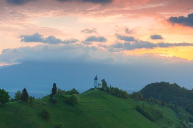 Jamnik, Julian Alps, Slovenya 'daki küçük şirin St. Primus ve Felicia kilisesi ve güzel gündoğumu gökyüzü renkleri
