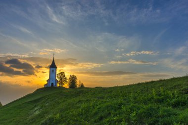 Jamnik, Julian Alps, Slovenya 'daki küçük şirin St. Primus ve Felicia kilisesi ve güzel gündoğumu gökyüzü renkleri