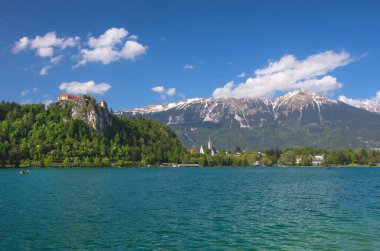 Bled Gölü 'nde güneşli bir bahar sabahı ve kayadaki eski ortaçağ şatosu, Slovenya' nın ünlü turistik merkezi.