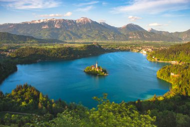 Bled Gölü ve Julian Alpleri 'nin havadan görünüşü, göl adası ve Slovenya' nın ünlü turistik merkezi olan Mary 'nin Varsayımına adanmış büyüleyici küçük bir kilise.