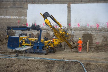 Graz / Avusturya - 09 Ekim 2019: inşaat alanında çalışan işçiler ve yerde delik açmak için kullanılan ağır iş makineleri