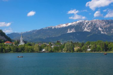 Bled Gölü 'nde güneşli bir bahar sabahı ve arka planda Julian Alps, Slovenya' nın ünlü turistik merkezi.
