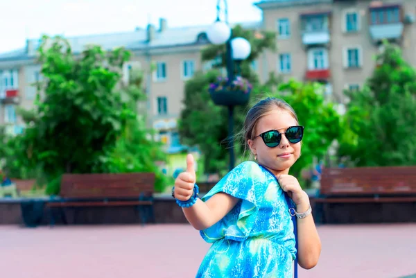 Retrato de uma menina com óculos no fundo da cidade — Fotografia de Stock