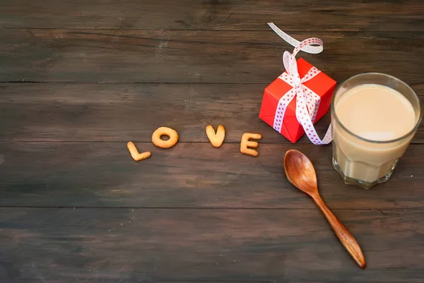 Слово любовь написана с печеньем буквы, подарочная коробка и остроумие кофе — стоковое фото