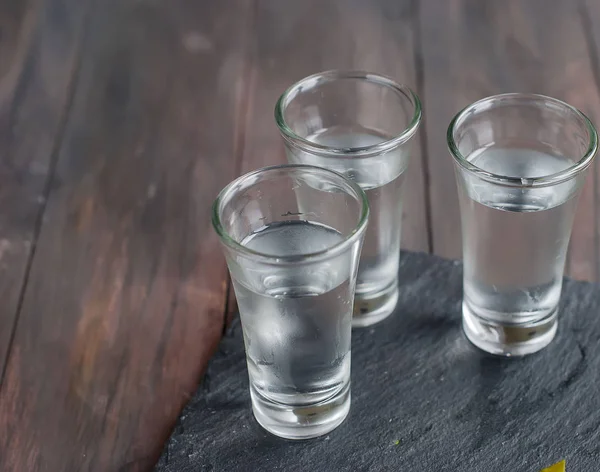 Маленький стакан с русской водкой и соленым огурцом — стоковое фото
