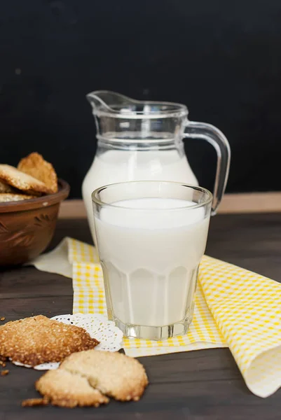 Sabrosas galletas y vaso de leche sobre fondo rústico de madera — Foto de Stock