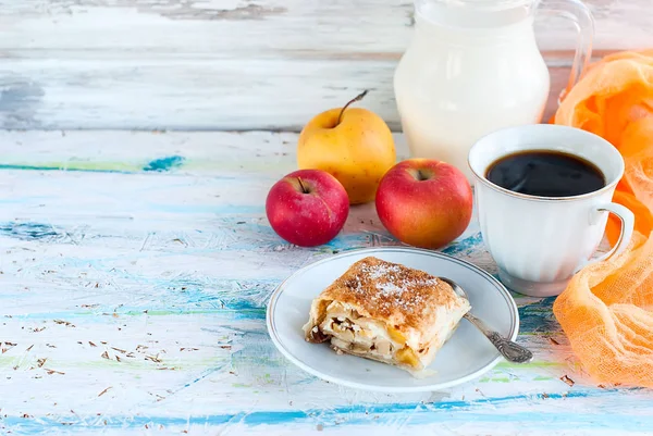 Strudel com maçãs, uma xícara de café preto e jarro de leite — Fotografia de Stock