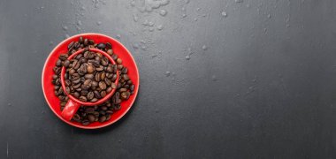 Kırmızı Kupası ve siyah bir zemin üzerine kahve çekirdekleri, 