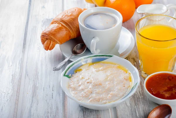 Café da manhã saudável com aveia com manteiga, croissant e café — Fotografia de Stock