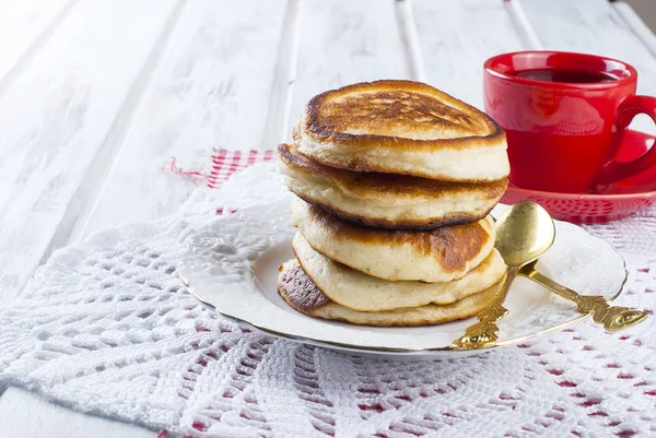 Στοίβα από pancakes σε ένα πιάτο σε ξύλινο λευκό φόντο — Φωτογραφία Αρχείου