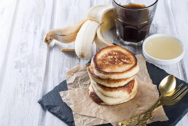 Pila de panqueques en un plato sobre fondo blanco de madera — Foto de Stock