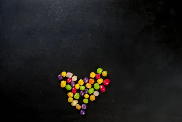 Corazón de caramelo sobre fondo negro vista superior — Foto de Stock